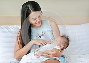 Mother carry sleeping baby at the bed room