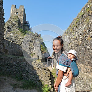 Mother carrying baby in sling on Trosky Castle