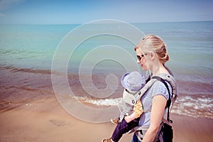 Mother carrying baby son along the beach at the Indiana Dunes National Park