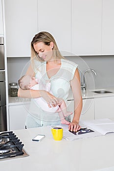 Mother carrying her baby in kitchen