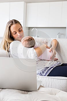 Mother carrying her baby in living room