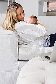 Mother carrying her baby in living room