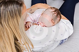 Mother carrying her baby in living room