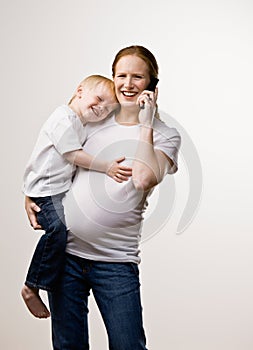 Mother carrying son while talking on phone