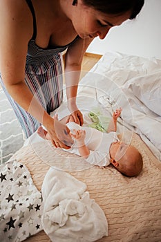 Mother change reusable diaper on her baby on the bed