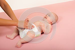 Mother changes the diaper of her baby