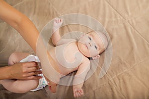 Mother changes the diaper of her baby