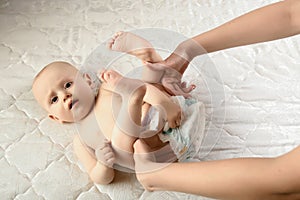 Mother changes diapers to her newborn baby. motherhood daily routine. family lifestyle. baby hygiene a damp napkin