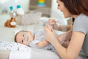 mother changing baby diaper