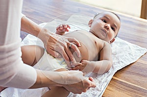 Mother changing baby diaper