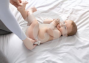 Mother changing baby`s nappy on white, top view
