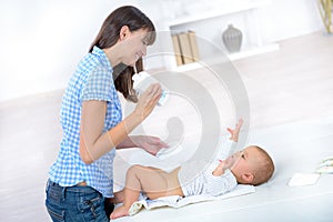 Mother changing babys diaper
