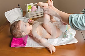 Mother changing diaper of adorable baby