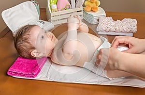 Mother changing diaper of adorable baby