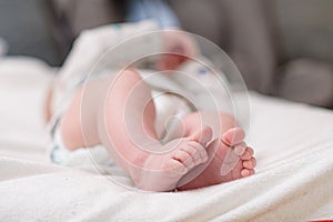 Mother changing diaper of adorable baby with a hygiene set for babies on the background