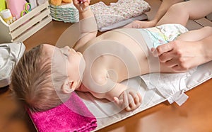 Mother changing diaper of adorable baby