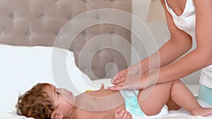 mother changing the nappy of her baby