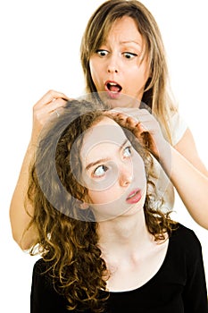 Mother checking child`s head for lice, emotion of surprise, consternation - louse on head