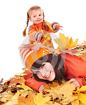 Mother with child on autumn orange leaves.