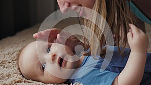 Mother and child on bed. Mom and baby boy in diaper playing in sunny bedroom. Parent and little kid relaxing at home