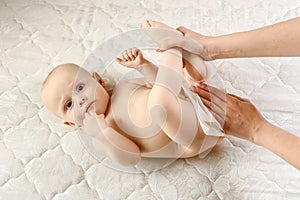 Mother and child body-care with focus on clean the baby`s buttock. Mom wipes baby wet wipes. Baby Care Hygiene