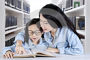 Mother and child with book in the library