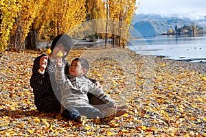 Mother and Child Boy Son plays in fallen leaves photo
