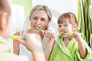 Mother with child brush teeth