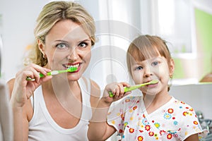 Mother and child brushing teeth in bathroom photo