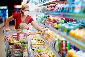 Mother and child buying fruit in supermarket