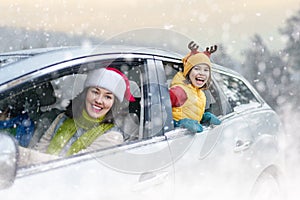 Mother, child and car on snowy winter nature