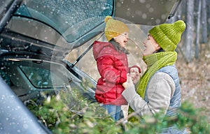 Mother, child and car on snowy winter nature