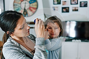 Mother with child crying in her arms at home