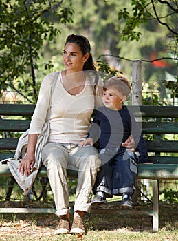 Mother and child cuddling sitting on bench