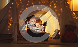 Mother and child daughter with a book and a flashlight before go