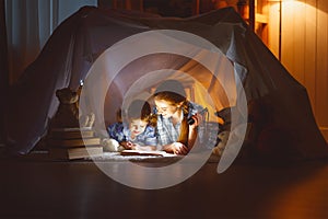 Mother and child daughter with a book and a flashlight before go