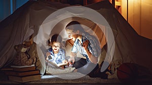 Mother and child daughter with a book and a flashlight before go