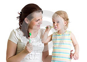 Mother and child daughter brushing teeth in bathroom