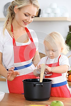 Mother and child daughter cooking pasta or salad for the breakfast. Concept of happy family in the kitchen