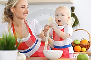 Mother and child daughter cooking pasta or salad for the breakfast. Concept of happy family in the kitchen