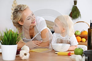 Mother and child daughter cooking pasta or salad for the breakfast. Concept of happy family in the kitchen