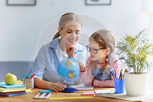 Mother and child daughter doing homework geography with globe