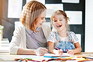 Mother and child daughter draws in creativity in kindergarten