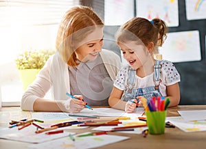 Mother and child daughter draws in creativity in kindergarten