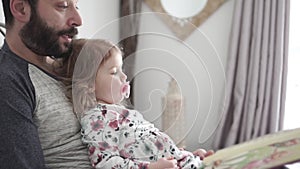 A mother and child daughter reading book in bed before going to sleep