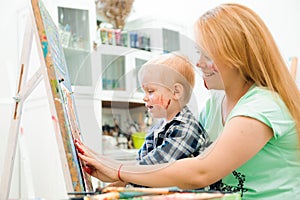 Mother and child draw a picture paints, art lesson.