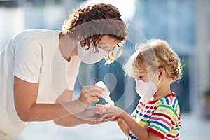 Mother and child with face mask and hand sanitizer