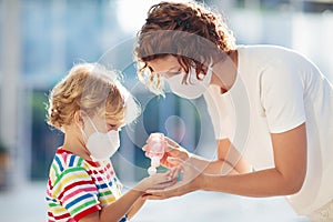 Mother and child with face mask and hand sanitizer