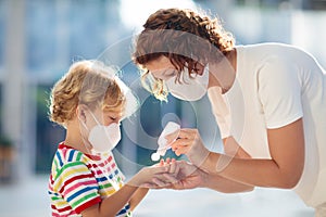 Mother and child with face mask and hand sanitizer