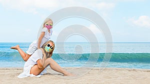 Mother, child in face masks have fun on sea beach